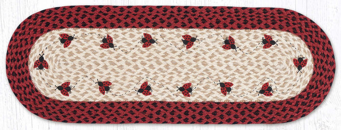 Table runner with ladybug design, black and red braided jute border.