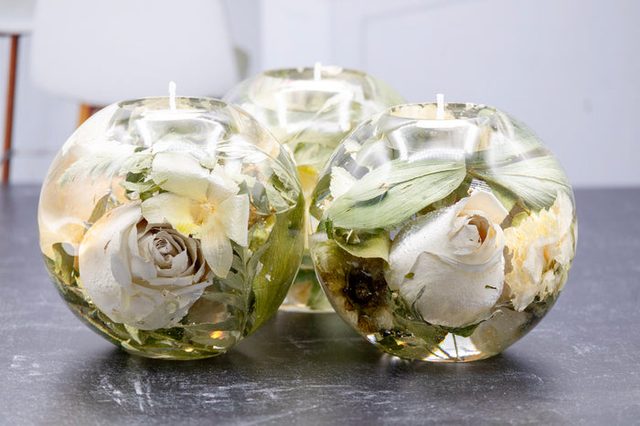 Tall portrait photo of a pressed flower tealight candle sphere with soft dried roses