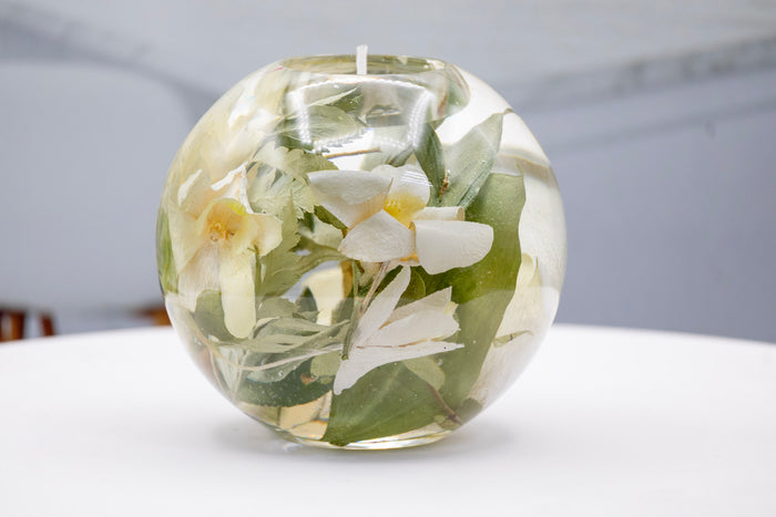 Tall portrait photo of a pressed flower tealight candle sphere with vibrant mixed dried flowers