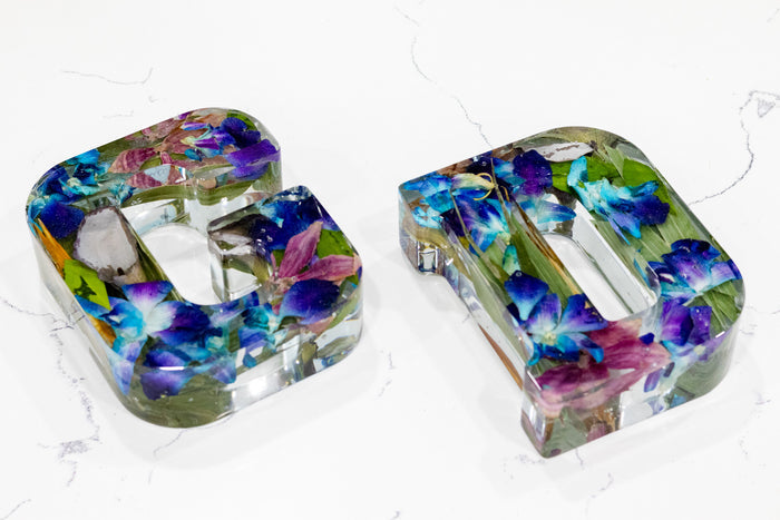 Landscape photo of a pressed flower 6-inch letter block with soft dried botanicals