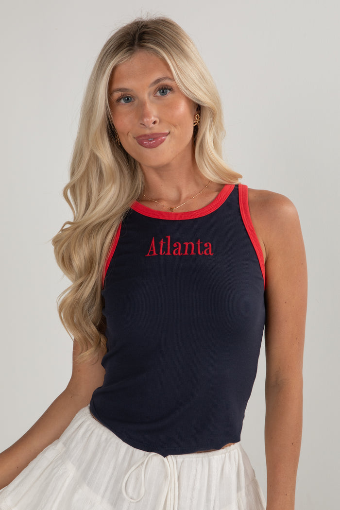 Woman wearing a black tank top with 'Atlanta' printed in red on a plain background