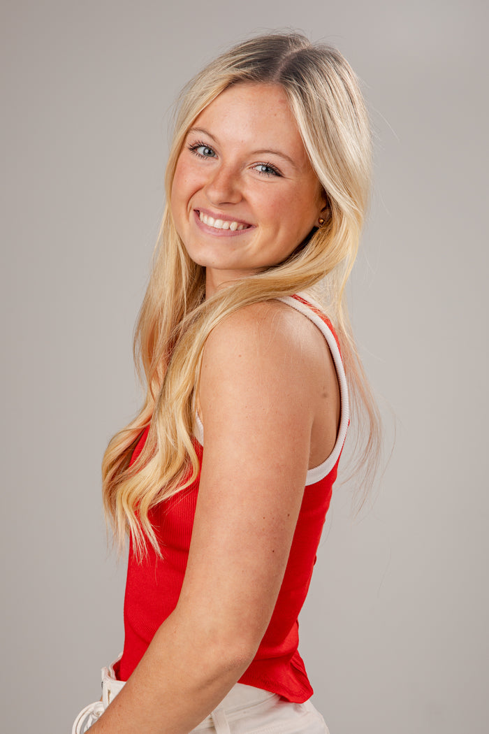 Woman wearing a red tank top against a gray background