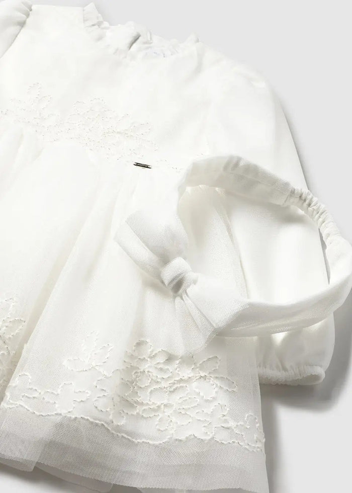 Closeup of Mayoral embroidered tulle dress showing delicate stitching, soft lining, and sheer Ivory fabric.