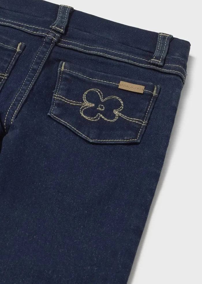 Closeup of Mayoral baby girl jeans showing back pocket detail, stitching, and dark stretch denim fabric.