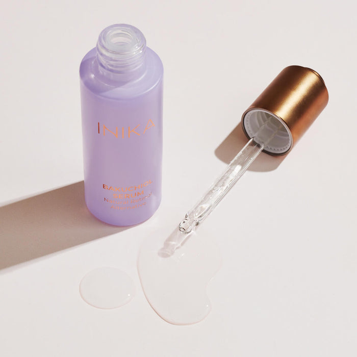 Open dropper bottle of certified organic Bakuchiol Serum laid flat on a surface, showing the product and texture.