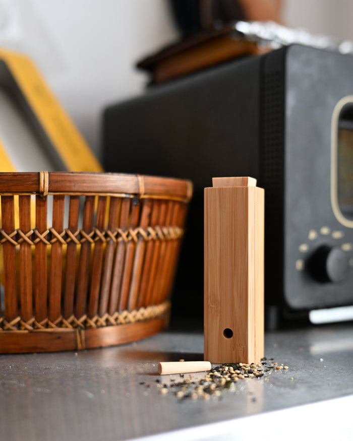 Bamboo Spice Container by Kohchosai Kosuga on a stainless steel counter with a basket and oven in the background.