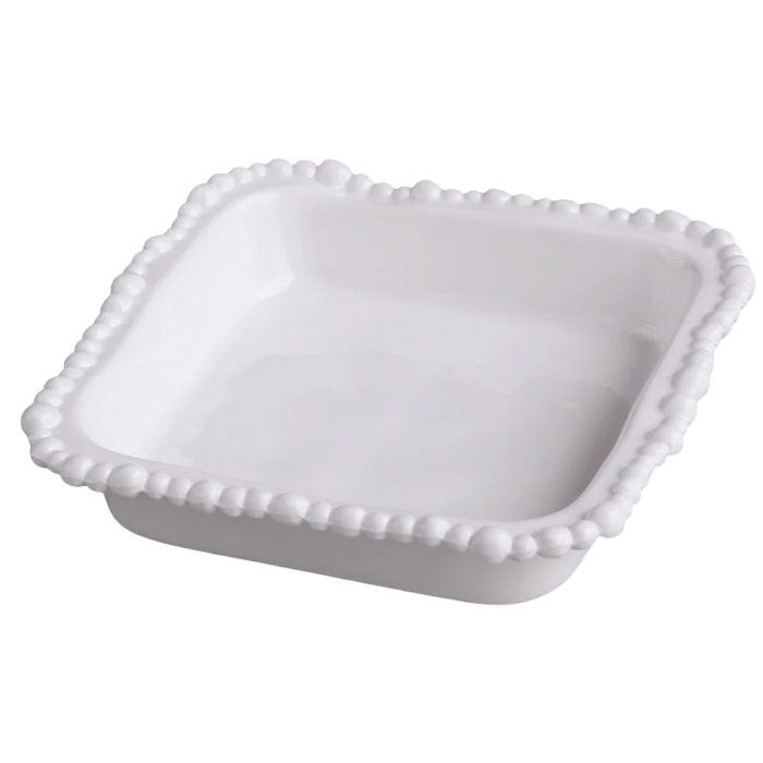 White ceramic dish with decorative edge on a white background