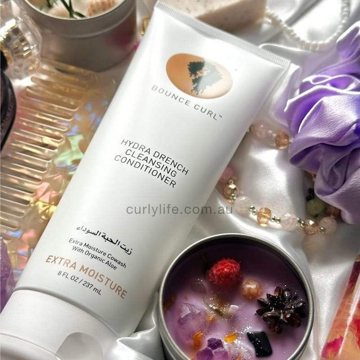 Bounce Curl Hydra Drench Cleansing Conditioner for extra moisture, styled with purple silk, beads, and crystals