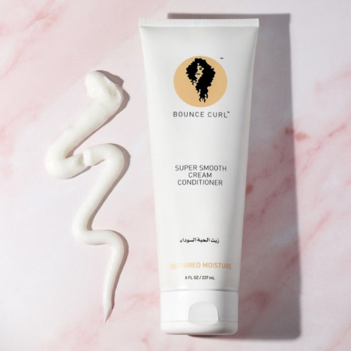 Bounce Curl Super Smooth Cream Conditioner for curly hair, with swirled product on pink marble background