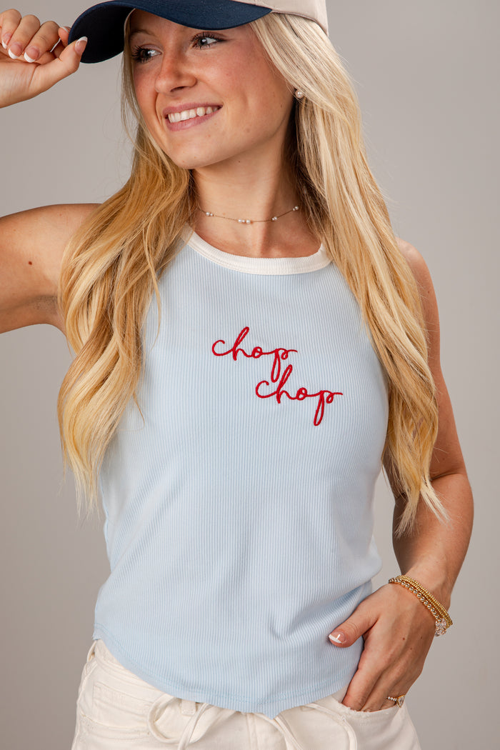 Woman wearing a light blue tank top with 'chop chop' text, smiling against a neutral background