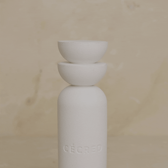 Hand pressing down on the dual bowl cap of Cécred Clarifying Shampoo & Scalp Scrub bottle, demonstrating the innovative stacked bowl dispensing mechanism