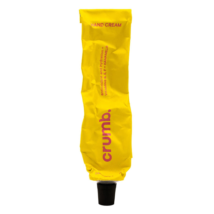 yellow tube of crumb hand cream raspberry & tulip on a white background