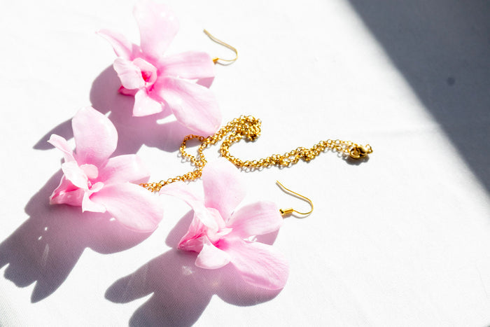 Landscape photo of a preserved orchid resin pendant necklace with mixed dried botanical layers