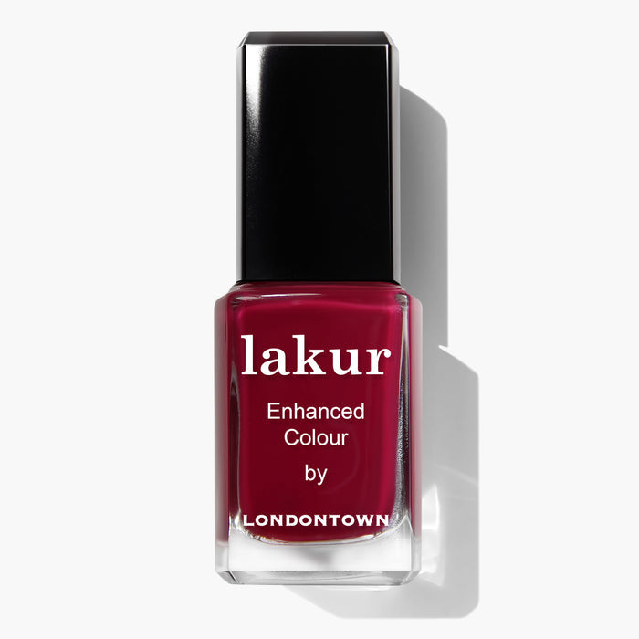 A bottle of Londontown Lakur nail polish, named Dragon Fruit, in deep red with a black cap. The label reads "lakur Enhanced Colour by LONDONTOWN." This vegan and cruelty-free formula ensures a perfect, guilt-free manicure.