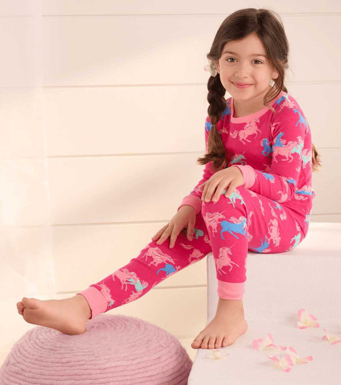 Girl wearing Hatley Frolicking Unicorns pajamas with colorful unicorn print and snug organic cotton comfort.