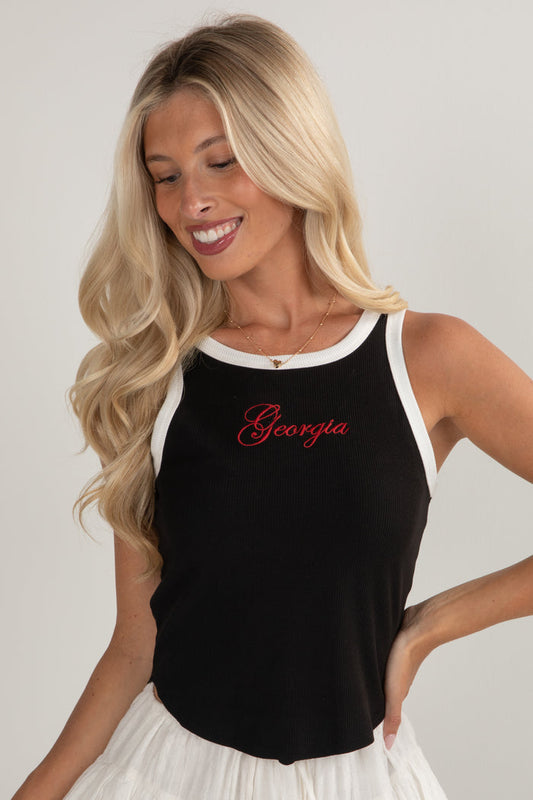 Woman wearing a black tank top with 'Georgia' printed in red on a plain background