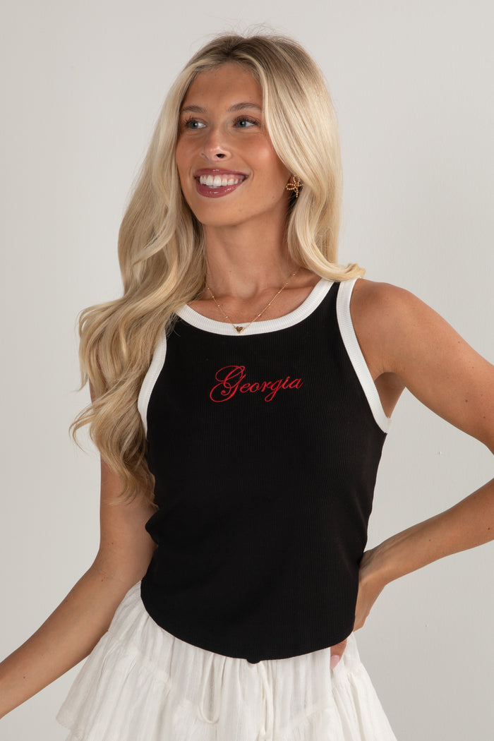 Woman wearing a black tank top with 'Georgia' printed on it against a plain background