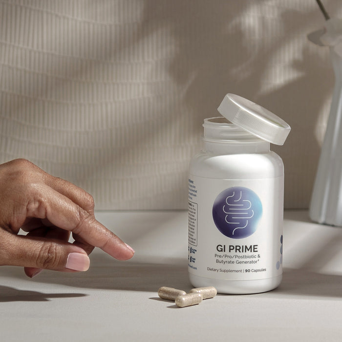 InfiniWell GI PRIME prebiotic, probiotic, and postbiotic supplement bottle with open lid and capsules.