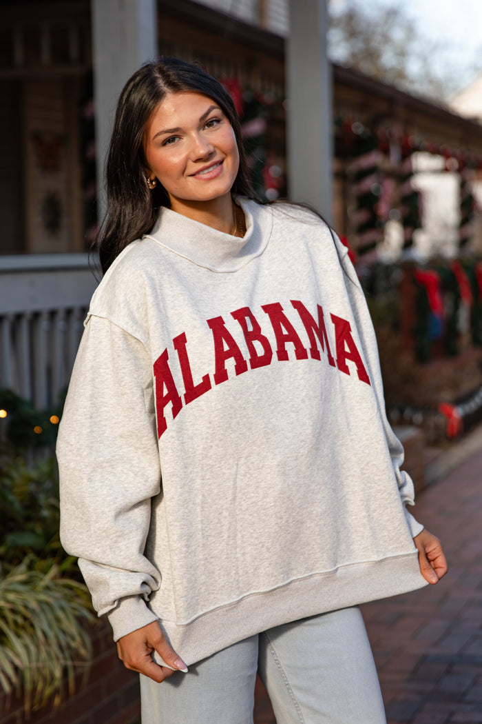 Person wearing a 'Alabama' sweatshirt standing outdoors.