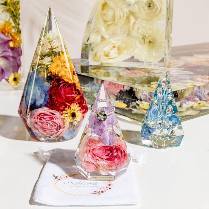 Large preserved flower ring holder holding several rings on a countertop