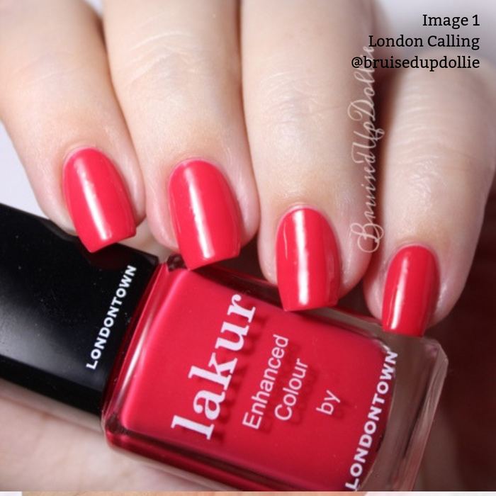 Close-up of a hand with nails painted in glossy red nail polish. The bottle of vegan, cruelty-free nail polish labeled "London Calling by LONDONTOWN" is also shown.