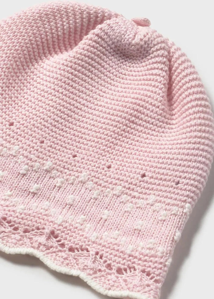 Closeup of Mayoral baby girl bow hat in Pink knit with delicate trim detail.