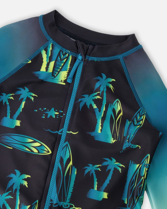 Close-up of neckline, zipper, and palm-tree surf print on black boys rashguard suit