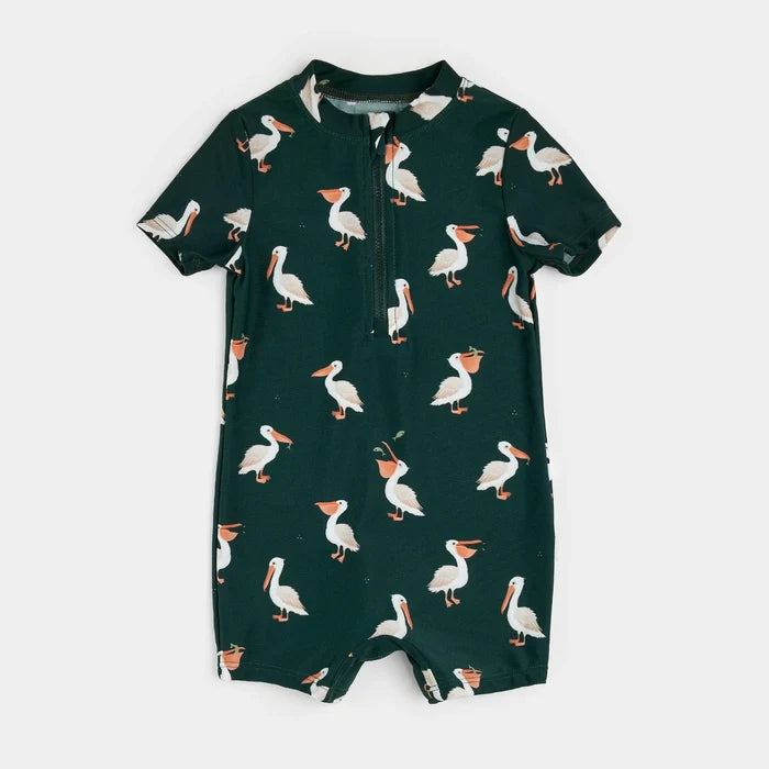 Deep sky pelican-print baby swim romper laid flat showing short sleeves and zipper front.