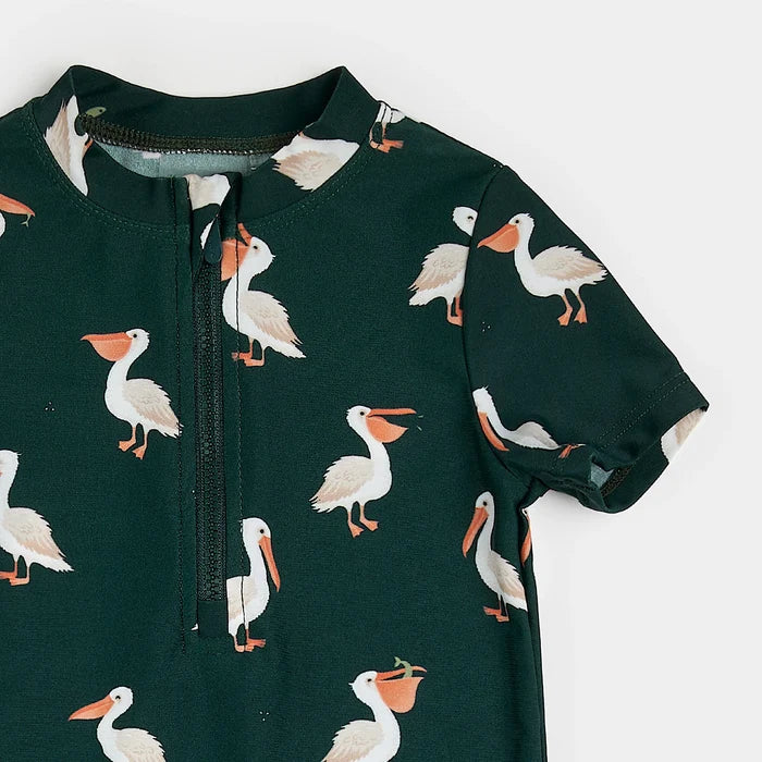 Close-up view of pelican print on deep sky blue recycled fabric of infant swim romper.