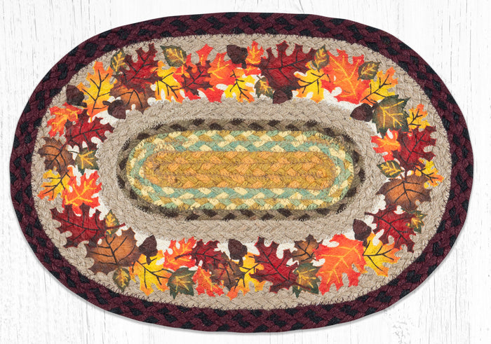 Oval braided placemat with autumn leaves design in orange, yellow, red and brown. Made from braided jute.