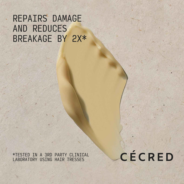 Cécred Reconstructing Treatment Mask formula swatch with Repairs Damage and Reduces Breakage by 2x claim text against a warm neutral textured background