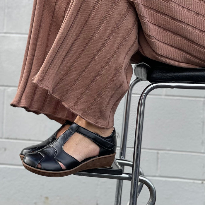 Smart black sandal in soft leather uppers. Velcro strap, wedge sole unit with enclosed heel and enclosed toe. Comfortable T-bar style women's sandal. Women's shoes with cushioned footbed.