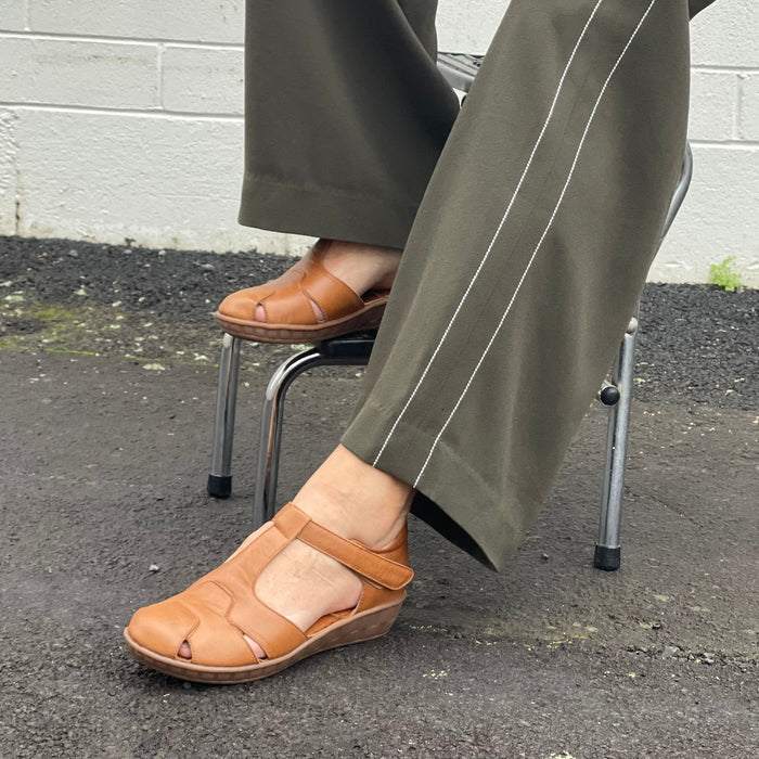 Smart tan sandal in soft leather uppers. Velcro strap, wedge sole unit with enclosed heel and enclosed toe. Comfortable T-bar style women's sandal. Women's shoes with cushioned footbed.