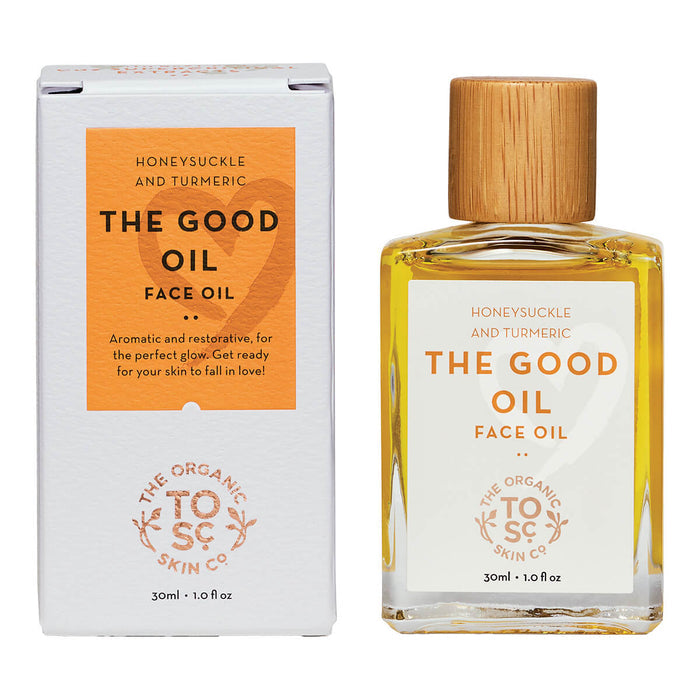 Bottle of certified organic face oil with honeysuckle and turmeric next to its box.