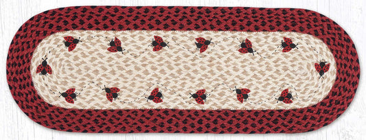 Table runner with ladybug design, black and red braided jute border.