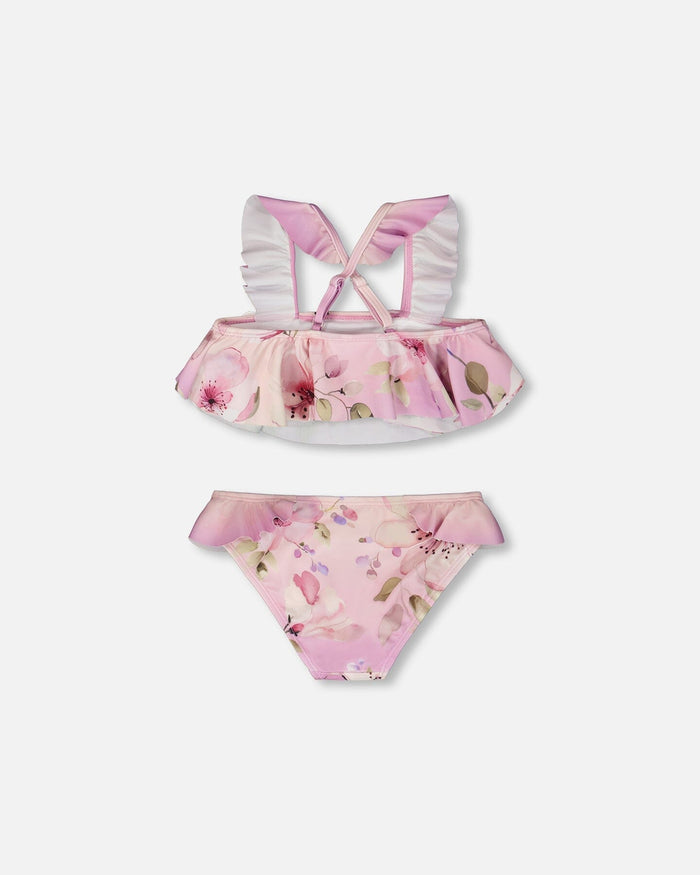 Detail shot of ruffled straps and floral print on purple girl two-piece swimsuit