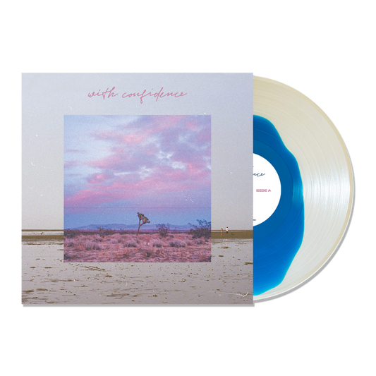 A Blue Inside Clear Variant vinyl by With Confidence is partially slid from its album cover, which displays a desert landscape beneath a pink and blue sky. With Confidence appears in pink cursive at the top.