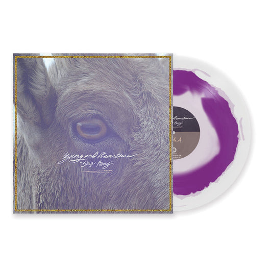 A purple and white splatter vinyl record partially slides out of an album cover featuring a close-up of an animal’s eye and fur, with cursive text reading Young And Heartless Stay Away and the track list on the back.